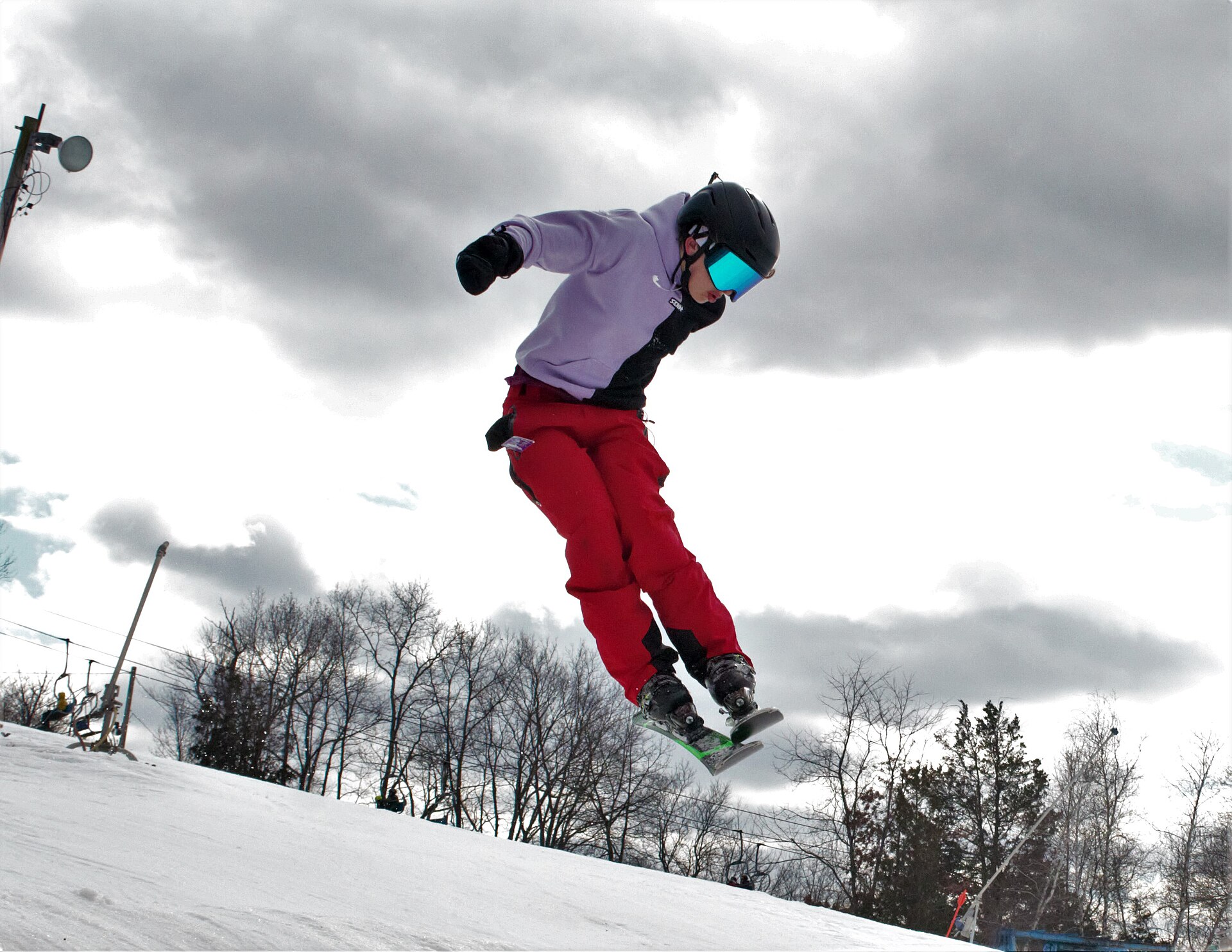 Skier catching air above a snowy terrain park