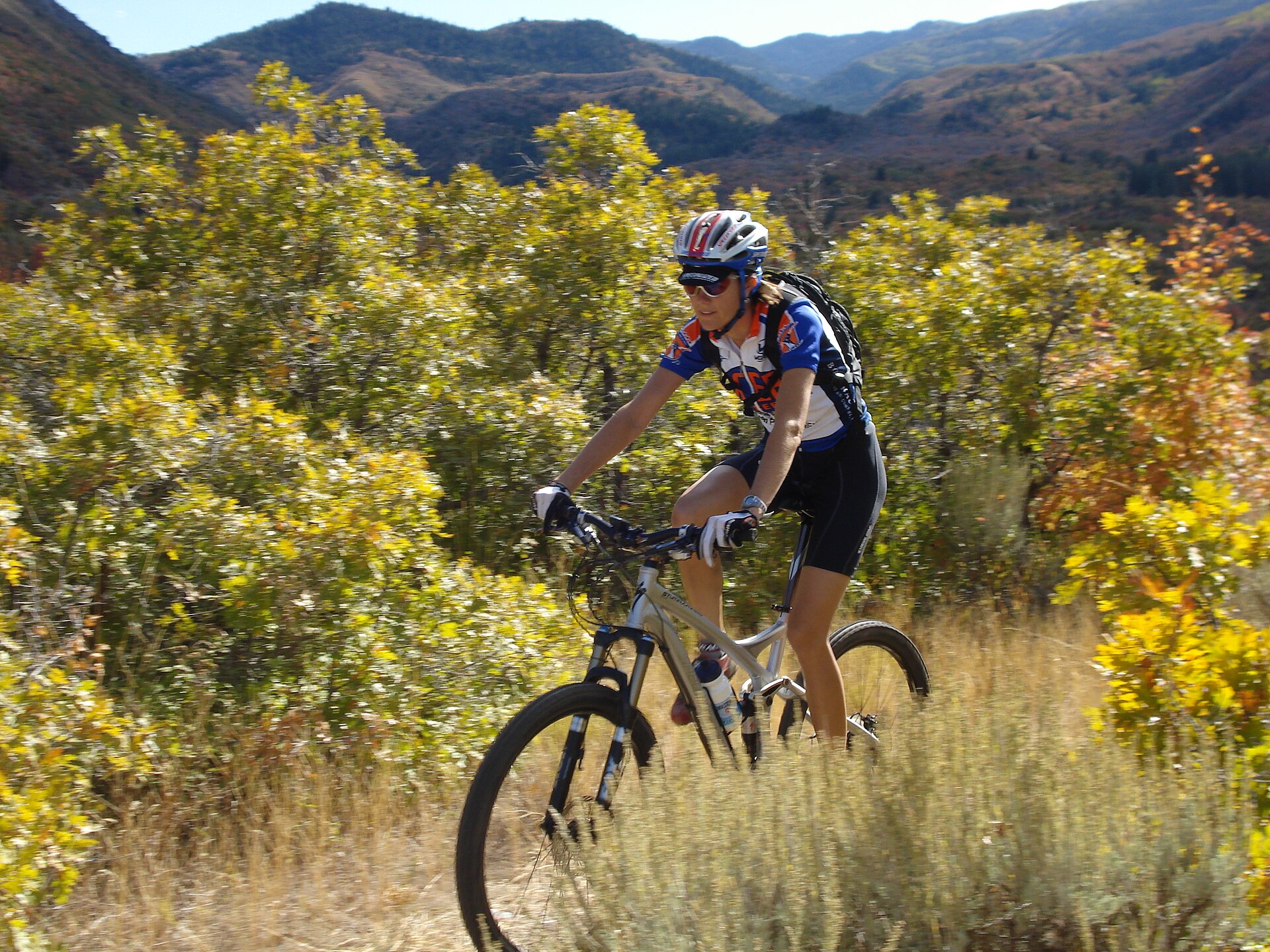 Mountain biker speeding along an autumn canyon trail