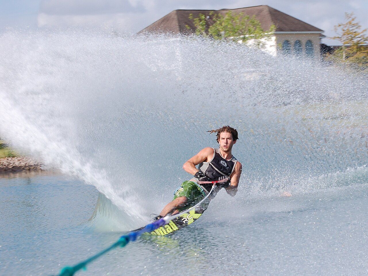 Water skier carving a spray of water on a lake
